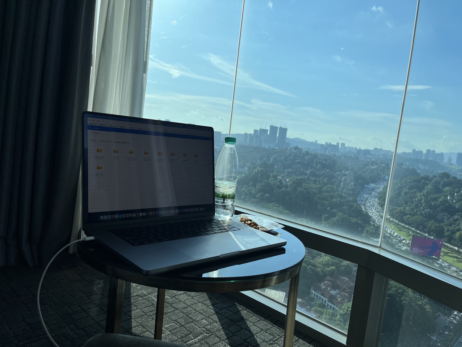KL skyline from hotel window with laptop